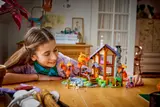 Girl admires completed LEGO cabin.