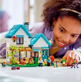 Child playing with LEGO Cozy House.