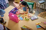 Child playing with open dollhouse cases.