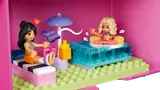 Minifigures by a pool inside the pink dollhouse case.