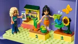 Minifigures in a garden inside the purple dollhouse case.