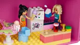 Minifigures in a kitchen inside the pink dollhouse case.