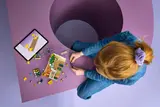 Child building LEGO with digital instructions.