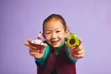 Child holding LEGO food.