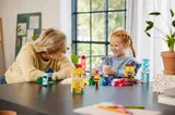 Adult and child building LEGO houses.