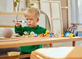 Boy playing with LEGO rocket.