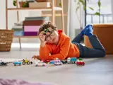 Child playing with LEGO cars.