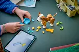 Building LEGO puppy with tablet.