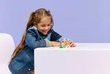 Girl smiling at LEGO hamster.