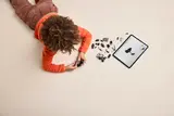 Child building LEGO with tablet instructions.