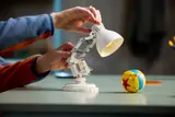 Hands adjusting LEGO Luxo Jr. head.