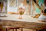 LEGO Dobby in sad pose with sock and locket on table.
