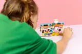 Child playing with the bakery set from behind.