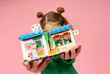 Child holding the bakery set, angled view.