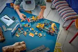 Child building LEGO with digital instructions.
