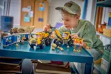 Child playing with LEGO construction vehicles.