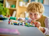 Child playing with LEGO Friends electric car set.