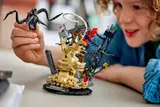 Child playing with LEGO Venom minifigure.