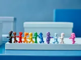 LEGO rainbow minifigures walking in line.