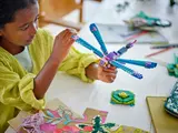 Child playing with LEGO dragonfly.