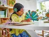 Child playing with LEGO peacock.