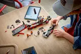 Child building LEGO F1 set with digital instructions.