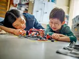 Child and adult playing with LEGO F1 set.