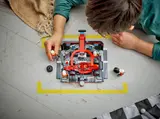 Child playing with F1 set on a floor track.