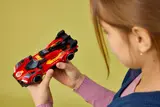 Girl holding LEGO Ferrari 499P from top.