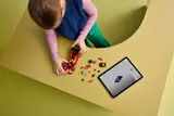 Child building LEGO Ferrari with tablet.