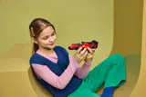 Girl holding LEGO Ferrari 499P.