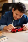 Child building Lego Ferrari SF90 XX Stradale