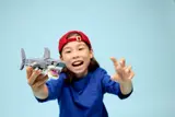 Child holding LEGO shark.