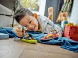 Child playing with minifigure and boat.