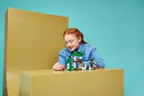 Child admires finished LEGO Minecraft set.