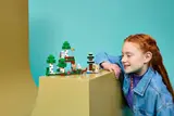 Child intently observing Minecraft LEGO set.