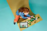 Child building LEGO Minecraft with tablet.