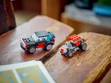 Two alternate cars on wooden surface.