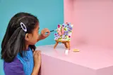Child adding piece to LEGO butterfly art.