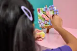 Child 'painting' LEGO butterfly art.