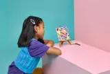 Child admiring LEGO butterfly art.