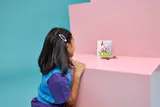 Child admiring LEGO flamingo art.