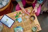 Hands building LEGO with iPad instructions.