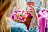 Child holding LEGO 'Sweet' drink mug.