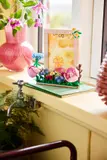 LEGO flower frame on a bright windowsill.