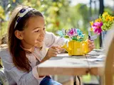 Girl playing with LEGO watering can.