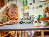 Child playing with LEGO Friends Camper Van.