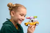Child holding LEGO Friends travel car