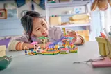 Child smiling while playing with LEGO set.