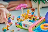 Child's hands placing LEGO figures.